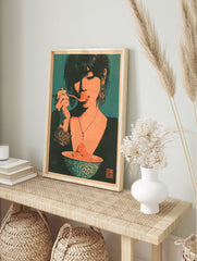 Stylized retro illustrative art print of a woman eating a strawberry from a bowl, teal, in an alternate framed mockup