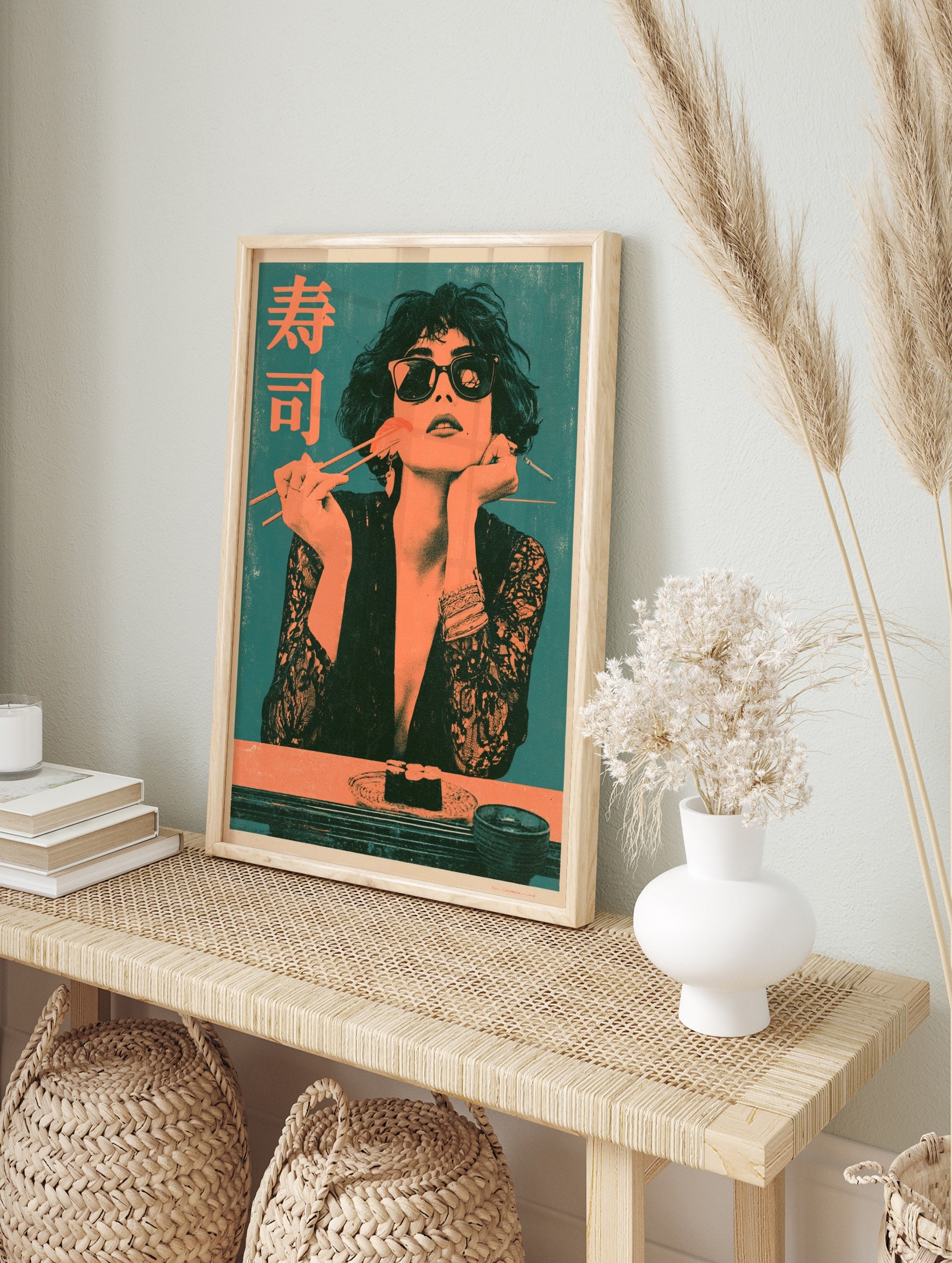 Retro style art print of a woman in sunglasses eating sushi with chopsticks and Japanese text, in an alternate framed mockup