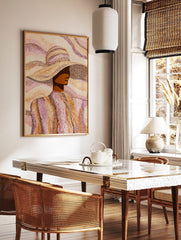 Pointillist art print of a woman in a wide-brimmed hat, rendered in brown, orange, and pink dots, in a styled room mockup