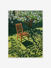 Wooden chair resting on green grass under a blooming white tree, casting dappled shadows on the lawn