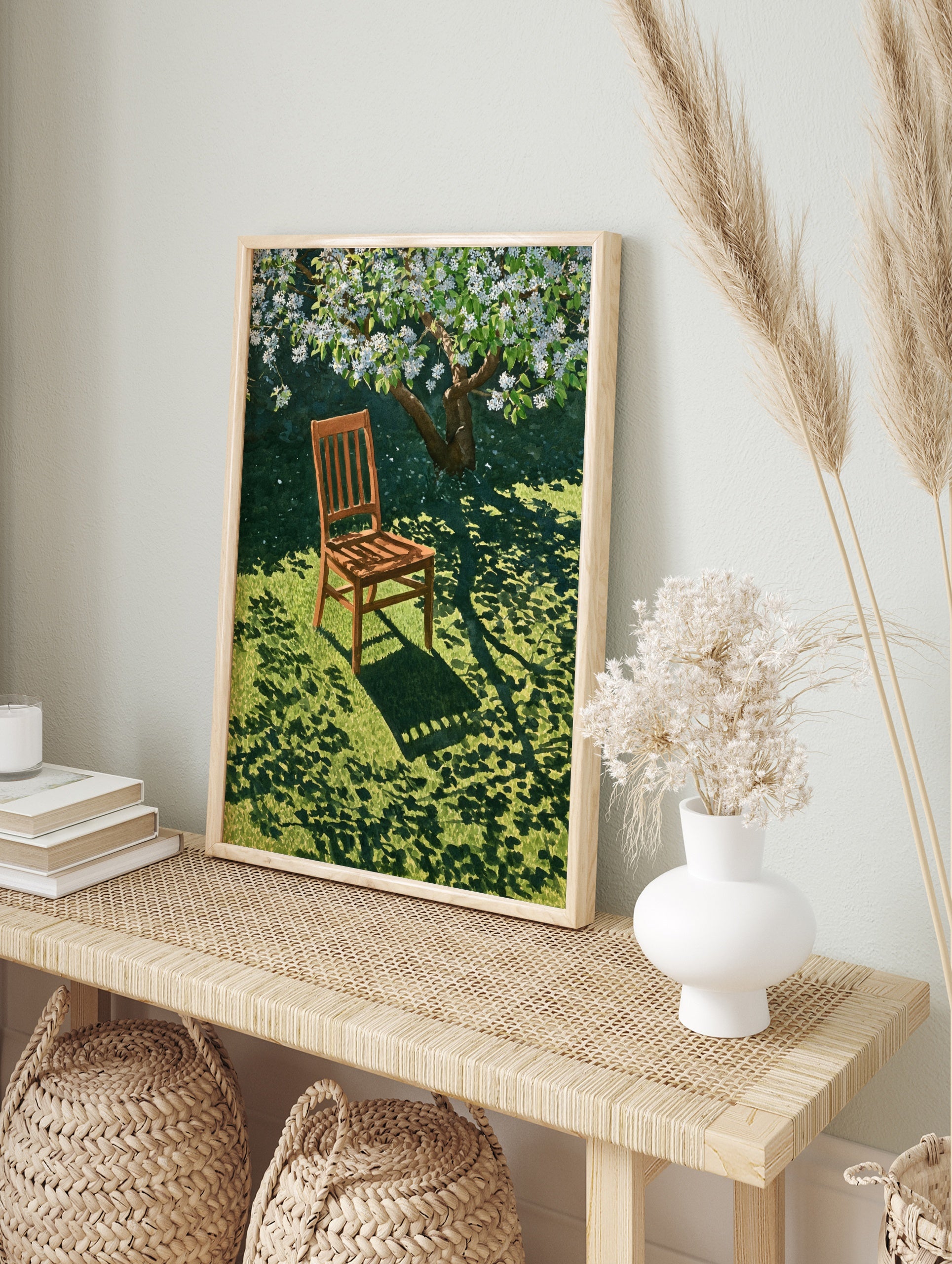 Wooden chair resting on green grass under a blooming white tree, casting dappled shadows on, in an alternate framed mockup