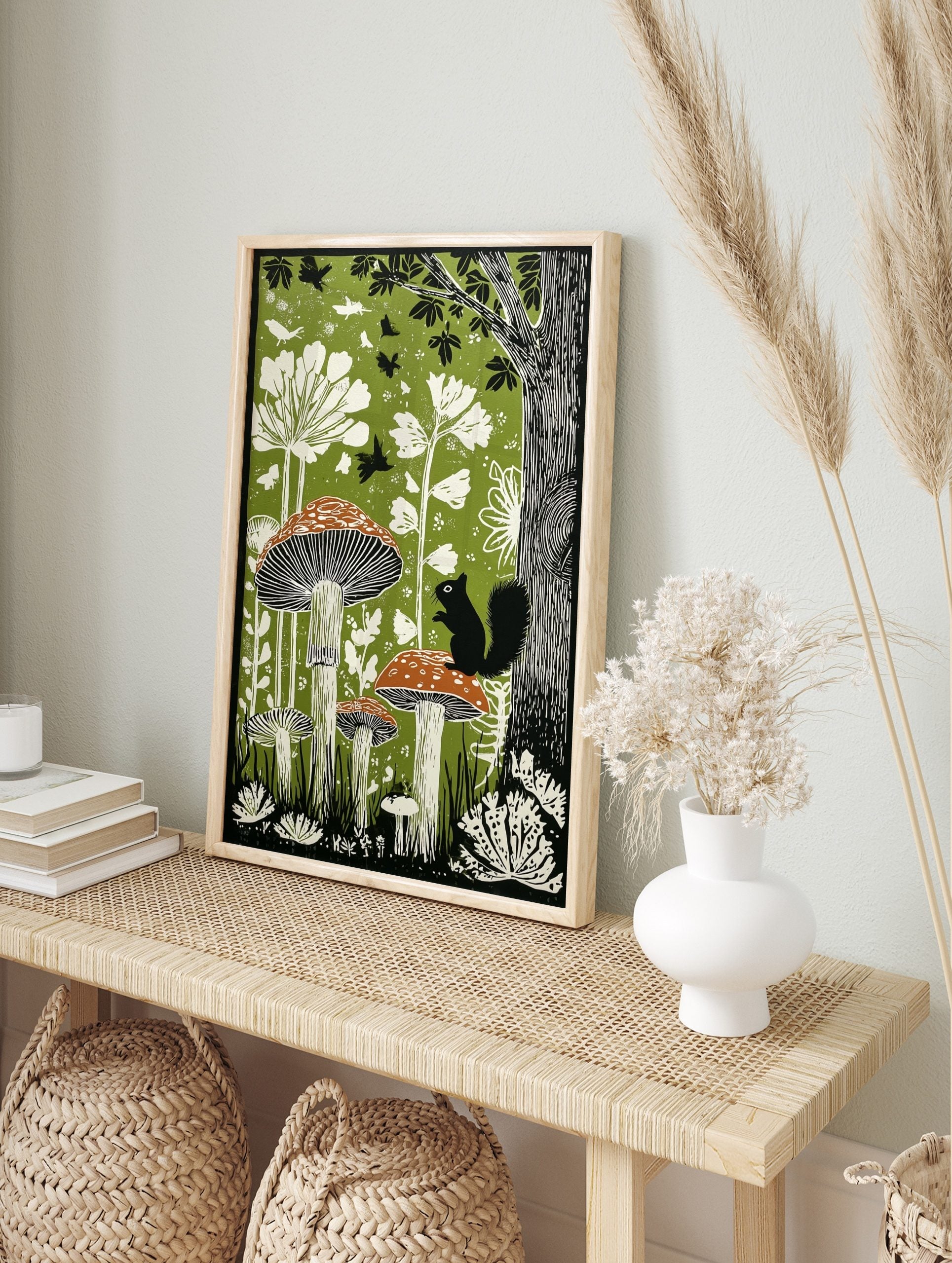 Illustrative woodland art print with large mushrooms, a black squirrel, white plants, and, in an alternate framed mockup